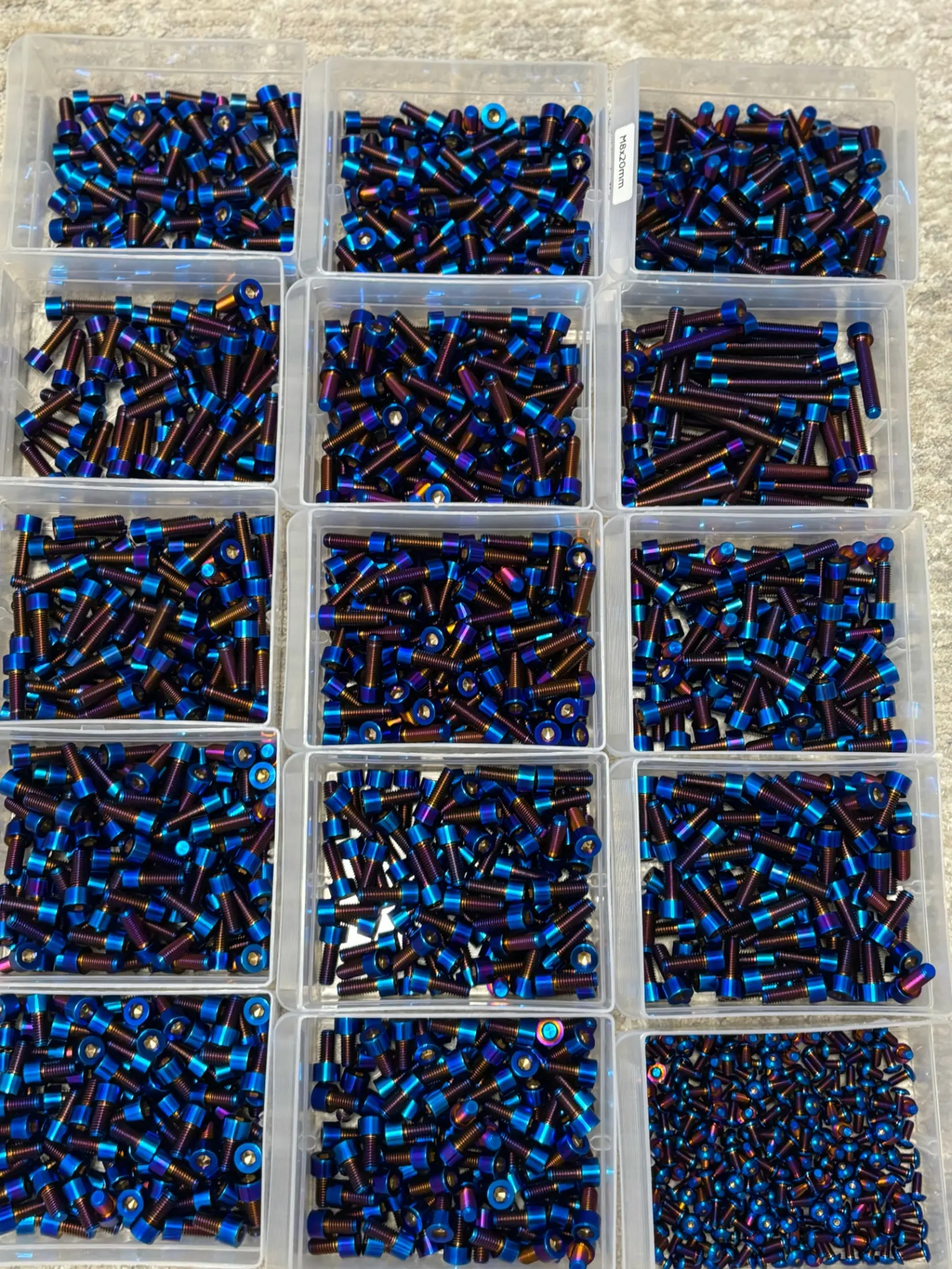 Burnt blue Grade 5 titanium bolts sorted in workshop trays
